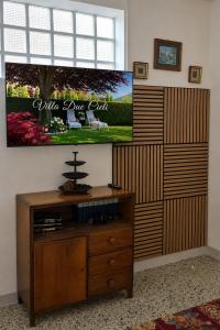 a living room with a tv and a wooden entertainment center at Iris Peaceful Apartment near Lake Como and Lugano in Lanzo dʼIntelvi