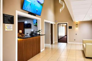 a lobby with a bar and a tv on the wall at Super 8 by Wyndham Champaign in Champaign