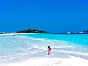 a little girl standing on a beach in the water at Valley Palm Seaview in Guraidhoo +41 photos