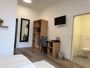 a bedroom with a bed and a desk with a television at Blue Stay 2 in Bremen