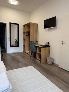 a room with a bed and a desk and a television at Blue Stay 2 in Bremen