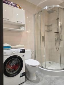 a bathroom with a washing machine and a toilet at Apartament Okulickiego 80 in Gorzów Wielkopolski +25 photos