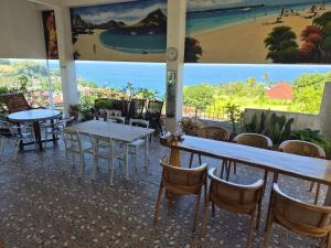 a restaurant with tables and chairs and a view of the beach at Arirang Sea View Homestay in Senggigi