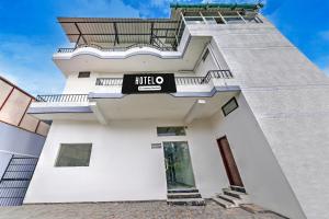 a white building with a hotel sign on it at Super Hotel O Clock Tower Dehradun Formerly Dooncity Suites in Dehradun