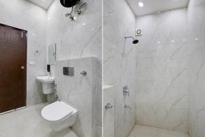 a white bathroom with a toilet and a shower at Super Hotel O Clock Tower Dehradun Formerly Dooncity Suites in Dehradun