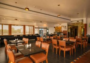 a restaurant with tables and chairs and a couch at Bloom Boutique Bangalore Palace Rd in Bangalore