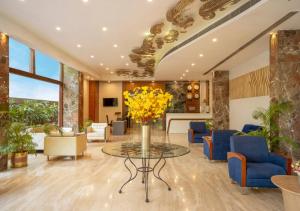 a lobby with a table with yellow flowers on it at Bloom Boutique Bangalore Palace Rd in Bangalore