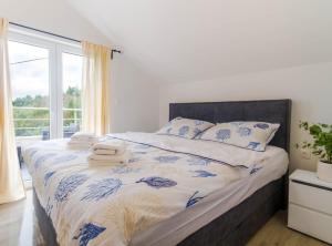 a bedroom with a bed with blue and white sheets and a window at Villa Marija Zaton in Dubrovnik
