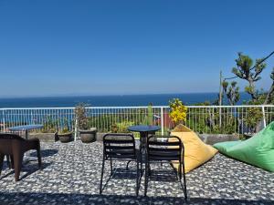 a table and two chairs on a patio with the ocean at Arirang Sea View Homestay in Senggigi +37 photos