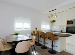 a kitchen with white walls and a wooden table and chairs at Villa Marija Zaton in Dubrovnik