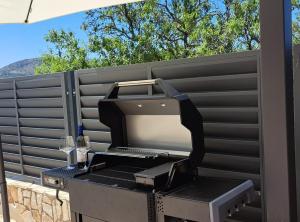 a grill sitting on a table next to a fence at Villa Marija Zaton in Dubrovnik