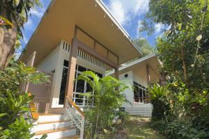 a house with a porch and trees at Beach Jungle in Ko Chang