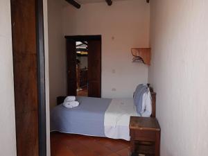 a bedroom with a bed with two towels on it at Hotel Casona de San Pedro in Curití