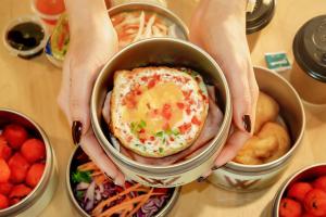 a person holding an egg in a can of food at Hotel Wizpark Ratchada in Bangkok