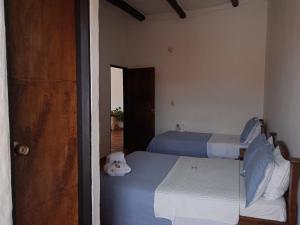 a bedroom with two beds and a door to a room at Hotel Casona de San Pedro in Curití +2 photos