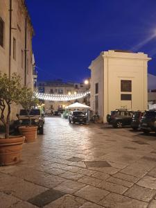 a street at night with cars parked in a parking lot at Futtitinni Home casamia in Palermo