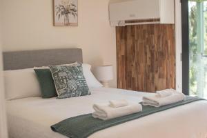 a bedroom with a bed with towels on it at the Lodge farm house in Hindmarsh Valley +46 photos