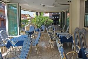 eine Reihe blauer Stühle und Tische auf einer Terrasse in der Unterkunft Hotel Royal in Misano Adriatico