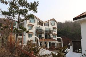 a large white building with balconies on it at Statehouse pension Incheon in Incheon