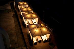 a row of tables with lit up umbrellas at night at Statehouse pension Incheon in Incheon +13 photos