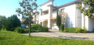 a white building with a tree in front of it at Holiday Home in Gevgelija