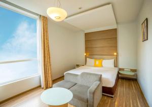 a hotel room with a bed and a chair and a window at Bloom Boutique Bangalore Palace Rd in Bangalore +21 photos