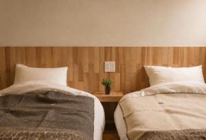 two beds sitting next to each other in a bedroom at mizuki natural villa Garden in Higashikawa