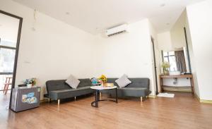 a living room with a couch and a table at Chuồn Chuồn Resort Nghia Lo - Free Sauna & Onsen in Yên Bái