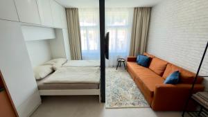 a living room with a couch and a mirror at Apartmán Vita Smart in Trenčín