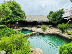 a pool in front of a house with a resort at Chuồn Chuồn Resort Nghia Lo - Free Sauna & Onsen in Yên Bái