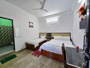 a bedroom with two beds and a television in it at Lumbini Garden Lodge in Rummindei +17 photos