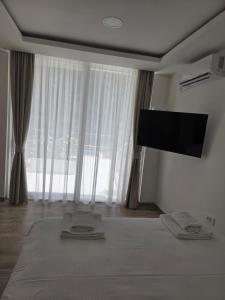 a bedroom with a bed and a flat screen tv at Luxury Studio Apartment with Sea View & Heated Pool in Kotor