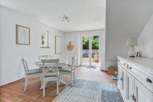 a white dining room with a table and chairs at Modern Holiday Home Pool & Wifi in Roquebrune-sur-Argens