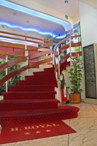 een rode trap in een gebouw met een rode loper bij Hotel Royal in Misano Adriatico