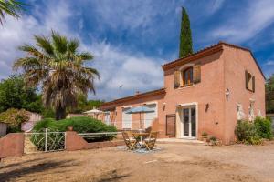 a house with a table and chairs in front of it at Modern Holiday Home Pool & Wifi in Roquebrune-sur-Argens
