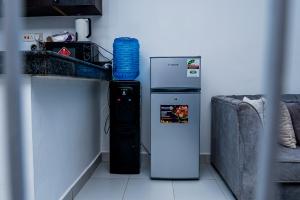 a blue water bottle is sitting next to a refrigerator at Serena Road Villa C in Mombasa