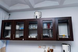 a wooden cabinet with dishes in it on a wall at Serena Road Villa C in Mombasa +13 photos