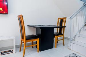 a black table with two chairs next to a staircase at Serena Road Villa C in Mombasa