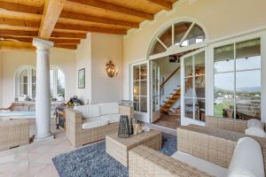 a large living room with couches and windows at Villa Tre Pini Garden Escape in Lugano