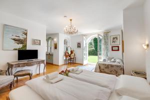 a living room with two beds and a television at Villa Tre Pini Garden Escape in Lugano