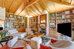 a living room filled with furniture and a tv at Villa Tre Pini Garden Escape in Lugano