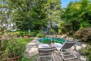 a garden with two chairs and a small pool at Villa Tre Pini Garden Escape in Lugano +47 photos
