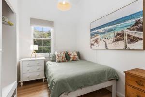 a bedroom with a bed and a painting on the wall at Lochaber in Point Lonsdale