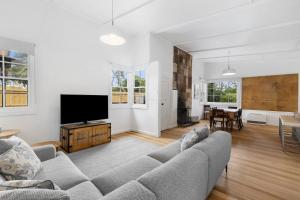 a living room with a couch and a flat screen tv at Lochaber in Point Lonsdale