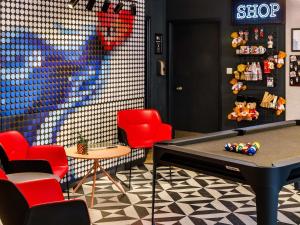 a play room with a pool table and red chairs at ibis London Greenwich in London