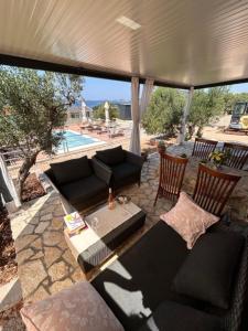 a patio with a couch and a table and chairs at Beach house Sofia in Otok Žut