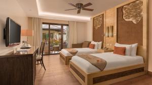 a hotel room with two beds and a television at Crimson Resort and Spa - Mactan Island, Cebu in Mactan +50 photos