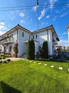 a white house with a grass yard at House Lake in Techirghiol