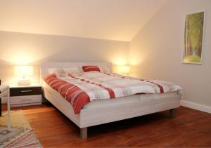a bedroom with a bed and a table with two lamps at 6-Personen-Fewo in Buchholz