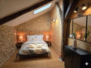 a bedroom with a large bed in a stone wall at La Colline Truffière in Sourzac +34 photos
